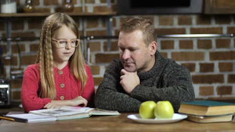 Dad helping his daughter with her homework.