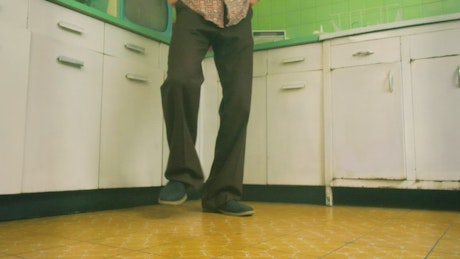 Dance of a man who dances in a kitchen of the 60s