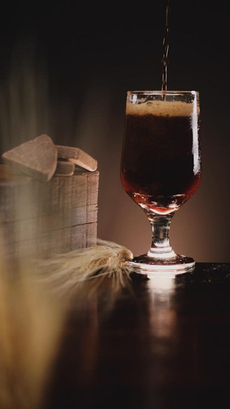 Dark beer with a lot of foam in a beautiful image composition.