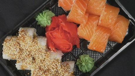 Decorated sushi on a plastic tray.