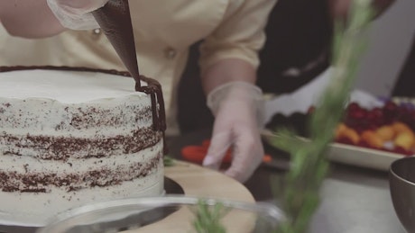 Decorating a cake with chocolate.