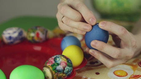 Decorating Easter Eggs with blue paint and stickers.