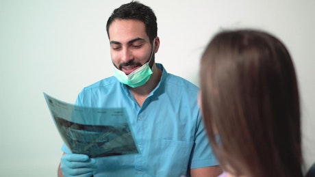 Dentist explaining a tooth x-ray to a patient
