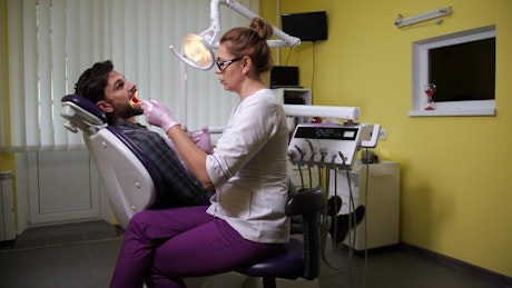 Dentist injecting a patient during treatment.