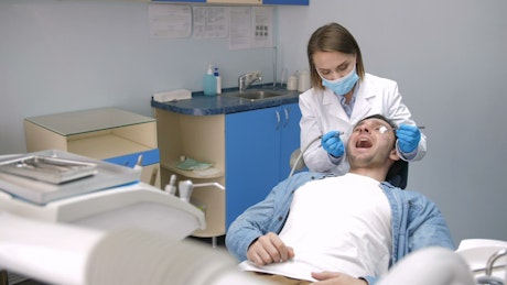 Dentist treating teeth at her clinic