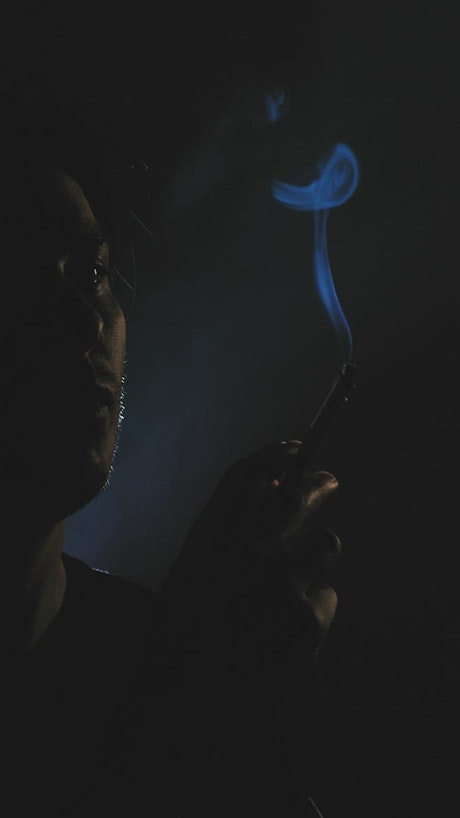 Depressed guy smoking in the dark.