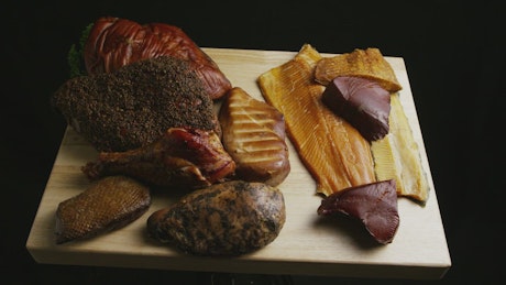 Different types of meat on a table on black background