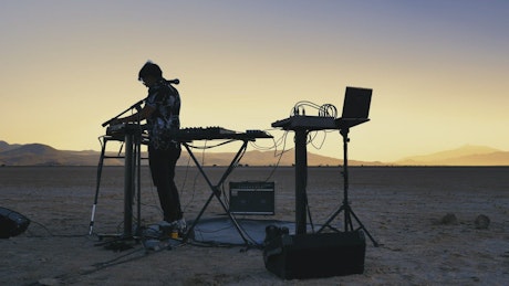 Dj mixing music in the middle of a vast desert