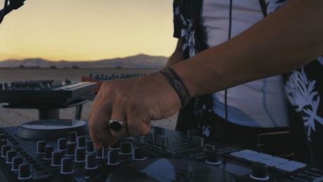 Dj mixing with his equipment in a desert.