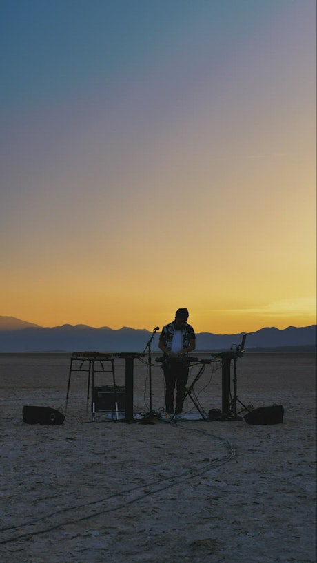 Dj playing in a desert at dusk
