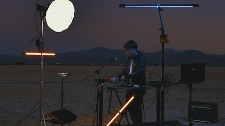 Dj playing with his equipment in an empty desert