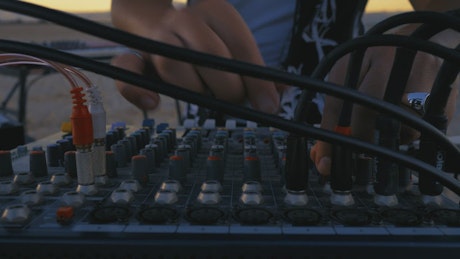 Dj using a console, mixing in a desert