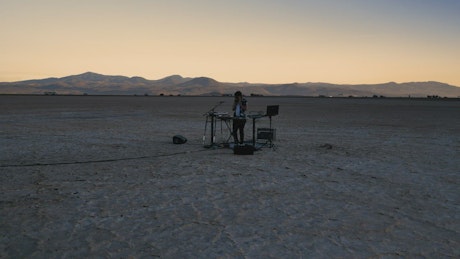 Dj with his equipment in the middle of a big desert