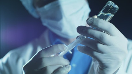 Doctor filling a syringe with anesthesia