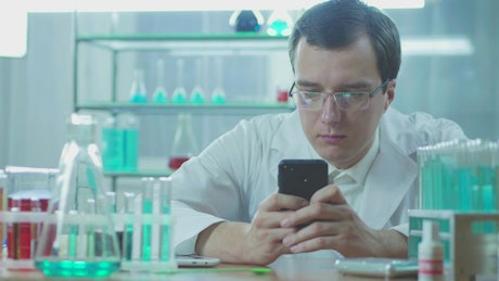 Doctor in the lab looking at his phone.