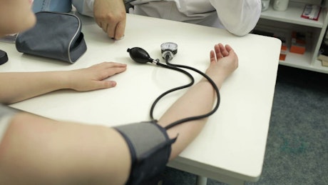 Doctor measuring the blood pressure of a patient.