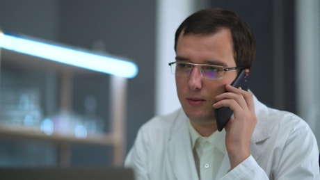 Doctor with glasses talking on the phone