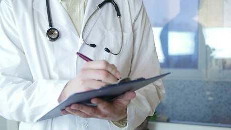 Doctor writing on a medical record