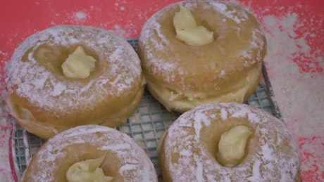 Donuts with icing sugar filled with pastry cream.