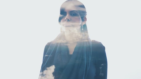 Double exposure video of a woman and the sky.
