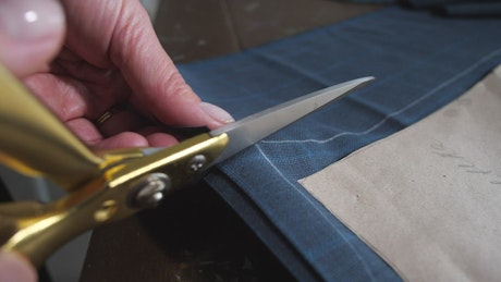 Dressmaker cutting fabric.