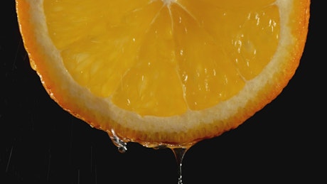 Drops of water dripping from an orange.