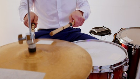 Drummer in shirt and bow tie playing drums.