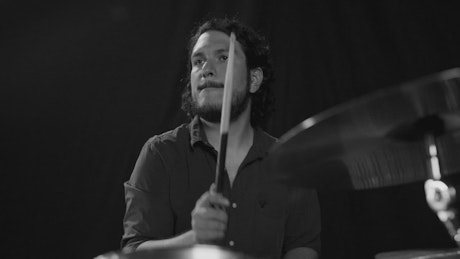 Drummer playing on a dark background.