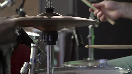 Drummer tapping out a beat on a drumkit.