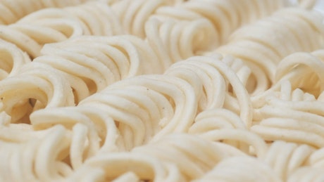 Dry instant noodles on a rotating surface.