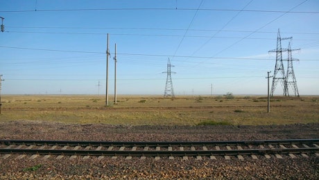 Electric towers from a train in motion.