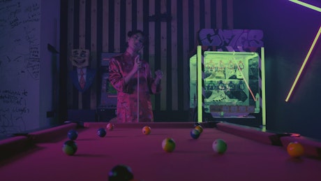 Elegant asian woman playing billiards in a game room