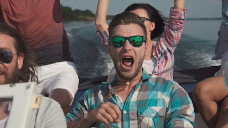 Excited friends sailing on a speed boat