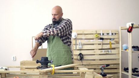 Expert carpenter prepares to work on a project in his workshop.
