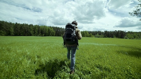 Explorer walking in a green meadow