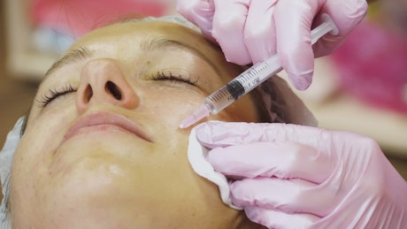 Face lifting injections on woman's face.