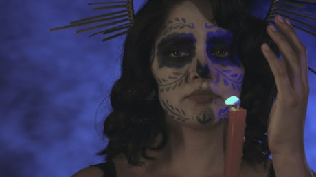 Face of a catrina with a candle on the day of the dead.