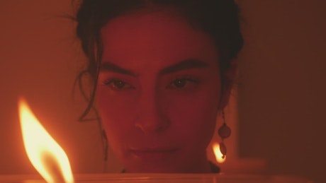 Face of a spiritual woman looking at the flame of a candle