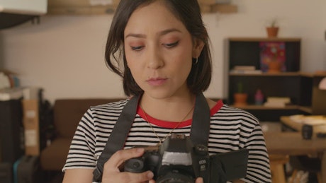 Face of a woman taking pictures with a camera.