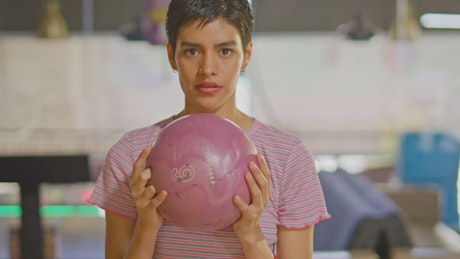 Face of a young woman preparing her bowling shot.