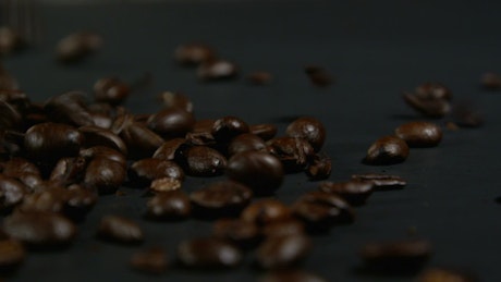 Falling coffee beans against a dark background