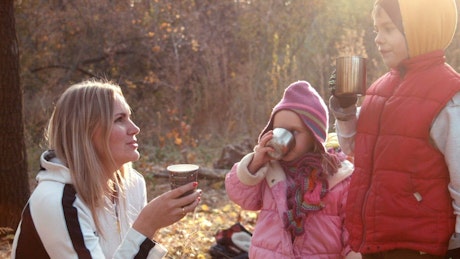 一家人在秋天的森林里喝热饮