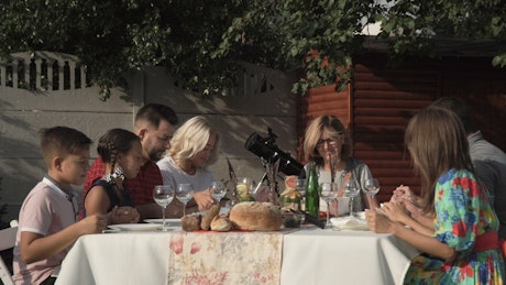 Family in a table outdoors praying before the meal
