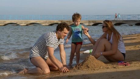 Family playing with wet sand.