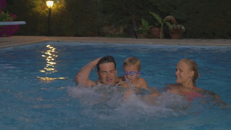 Family splashing in the pool.