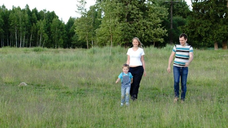 Family walking through wild grass.