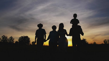 Family walking together at sunset.