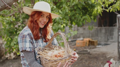 Farmer girl shows a fresh egg that has just been harvested.