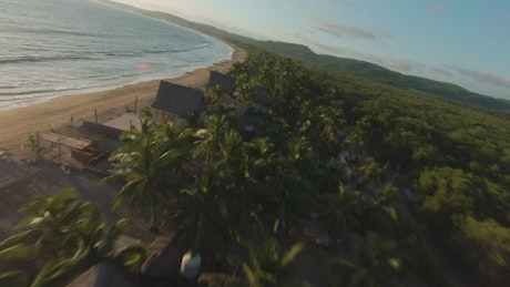 Fast and dynamic aerial drone tour through a beach.
