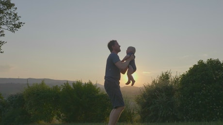 Father and his baby at sunset